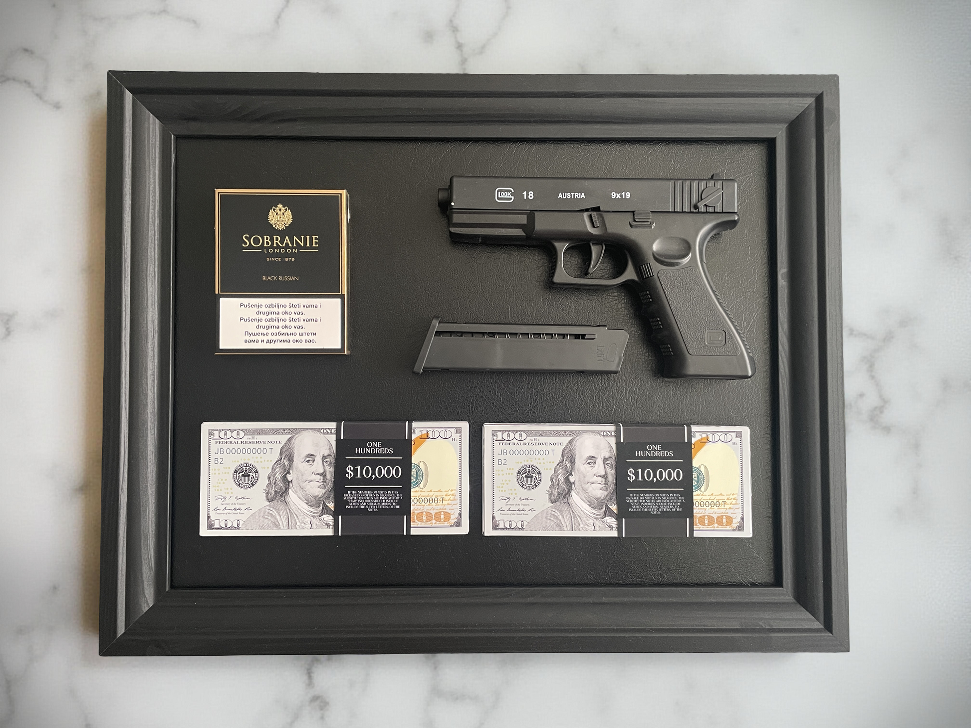 Glock gun with magazine, money, and Sobrane cigarettes on a black wooden frame.