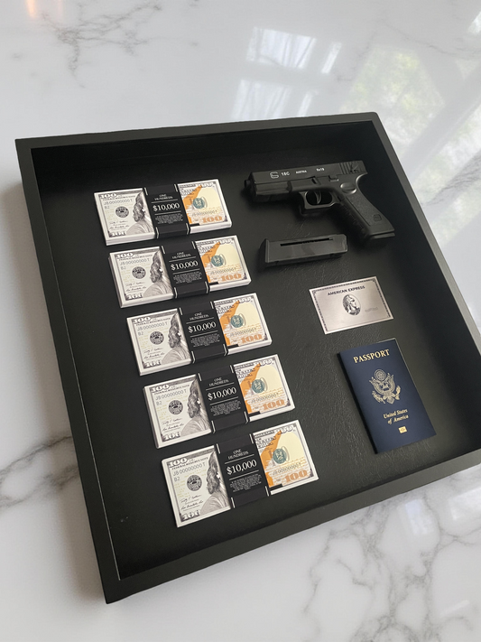 A framed display featuring currency notes, a firearm, and a passport — all set on a polished marble surface.
