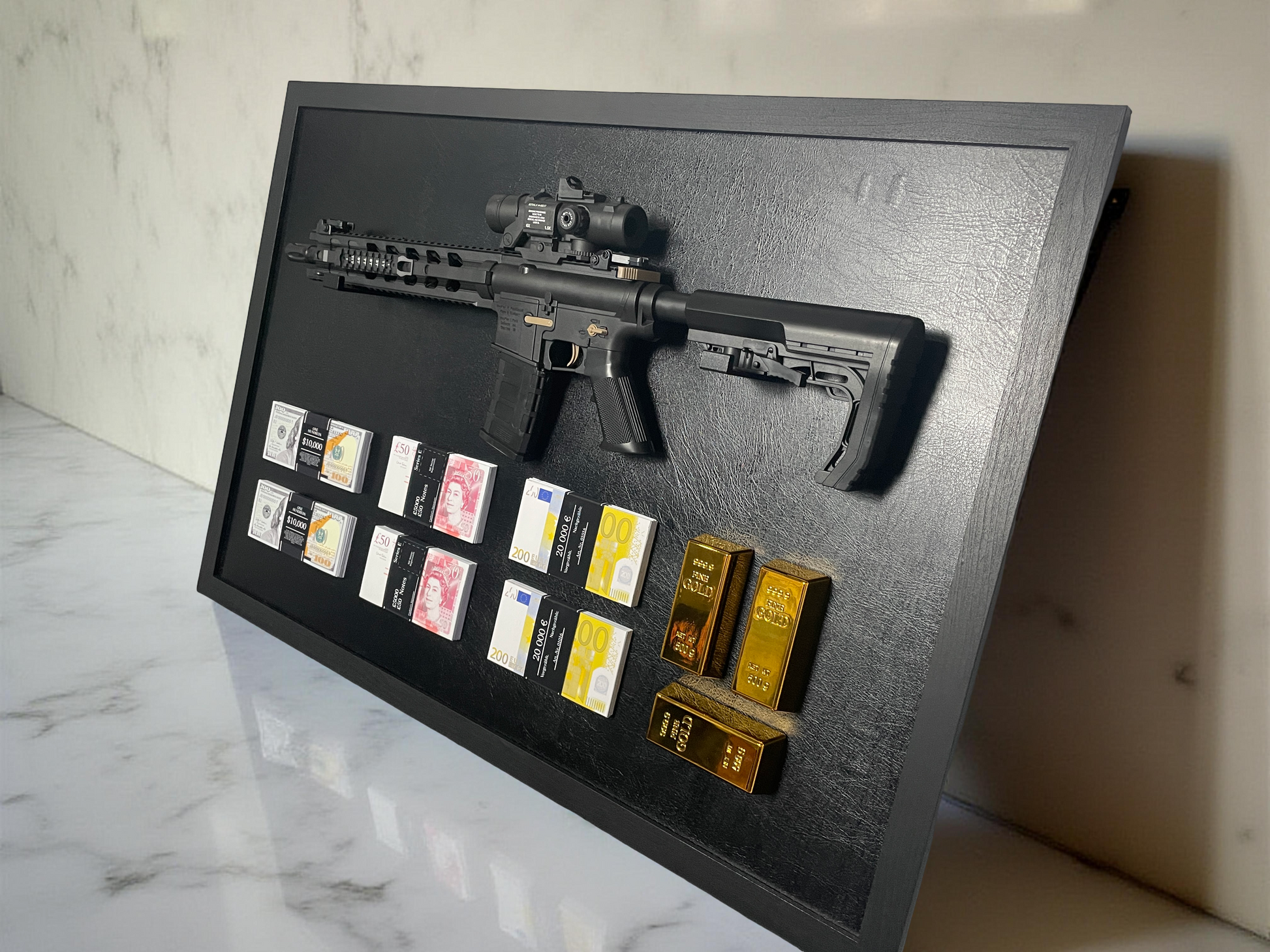 A framed display featuring a rifle, stacks of USD, GBP, and EUR currencies, and three gold bars.